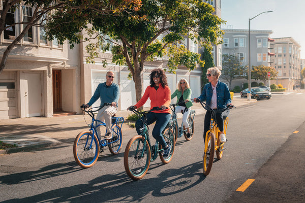 Group of cyclists riding Pedego electric bikes in San Francisco|Owners of Pedego McDowell Mountain, Jon and Molly Krick, standing inside their store.|Don DiCostanzo, CEO of Pedego, with his Pedego electric bike