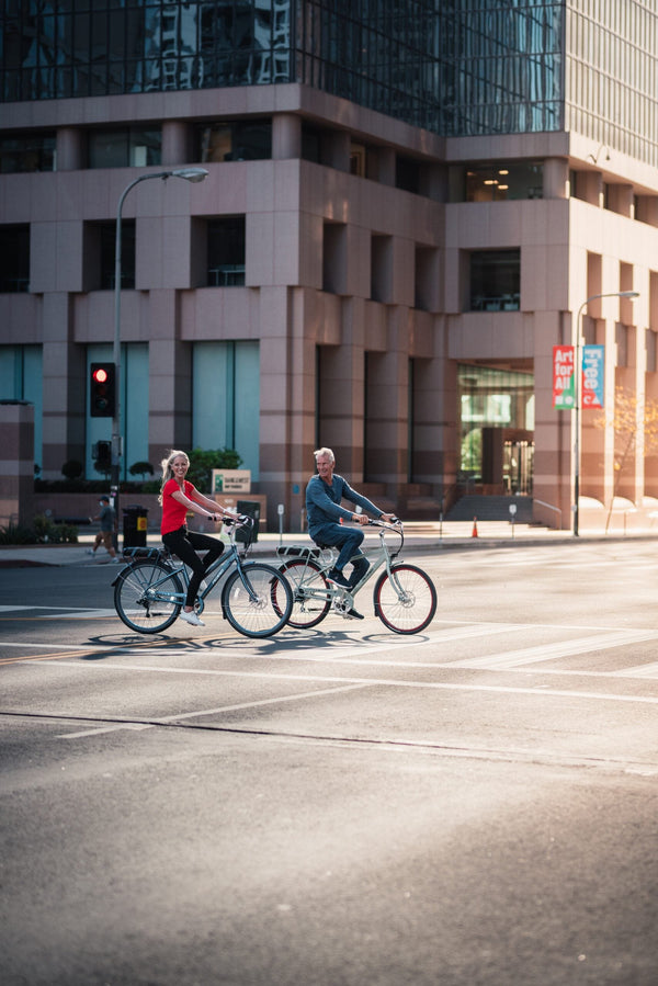 Couple enjoying a ride in the city on their Pedego Electric Bike