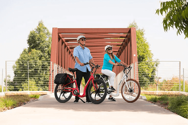 A couple enjoying a ride on their Pedego Boomerang Low-Step Electric Bikes