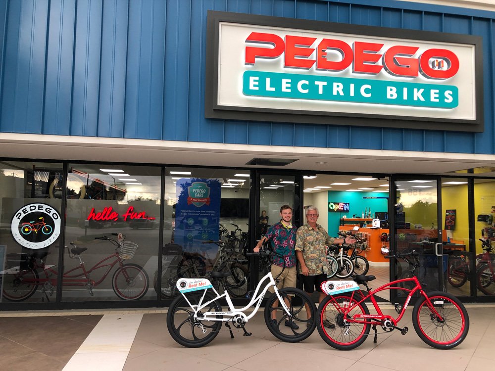 Owners Grego and Kyle of Pedego Boca outside their store with bikes.