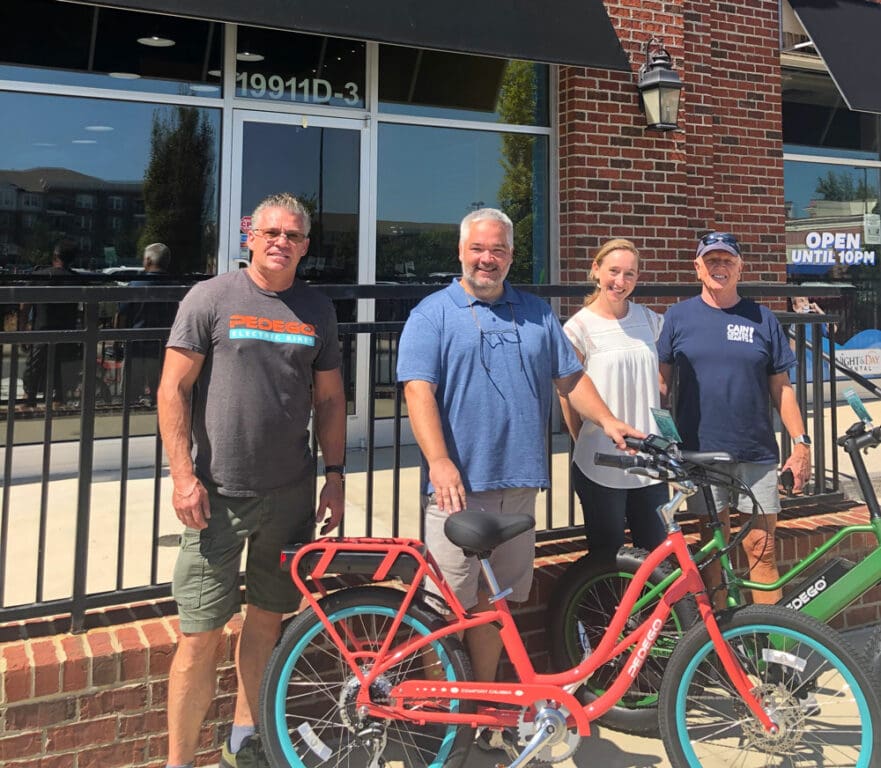 Owners of Pedego Lake Norman, Tom and Grace Kennedy, with Ray Liebert of Pedego HQ.