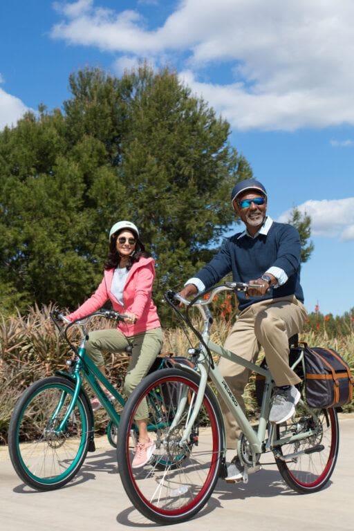A couple enjoying a ride on their Pedego City Commuter Electric Bikes