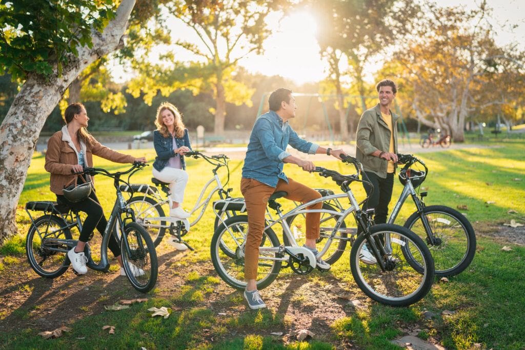 A group of friends enjoying a ride on their Pedego Electric Cruiser Bikes in the park
